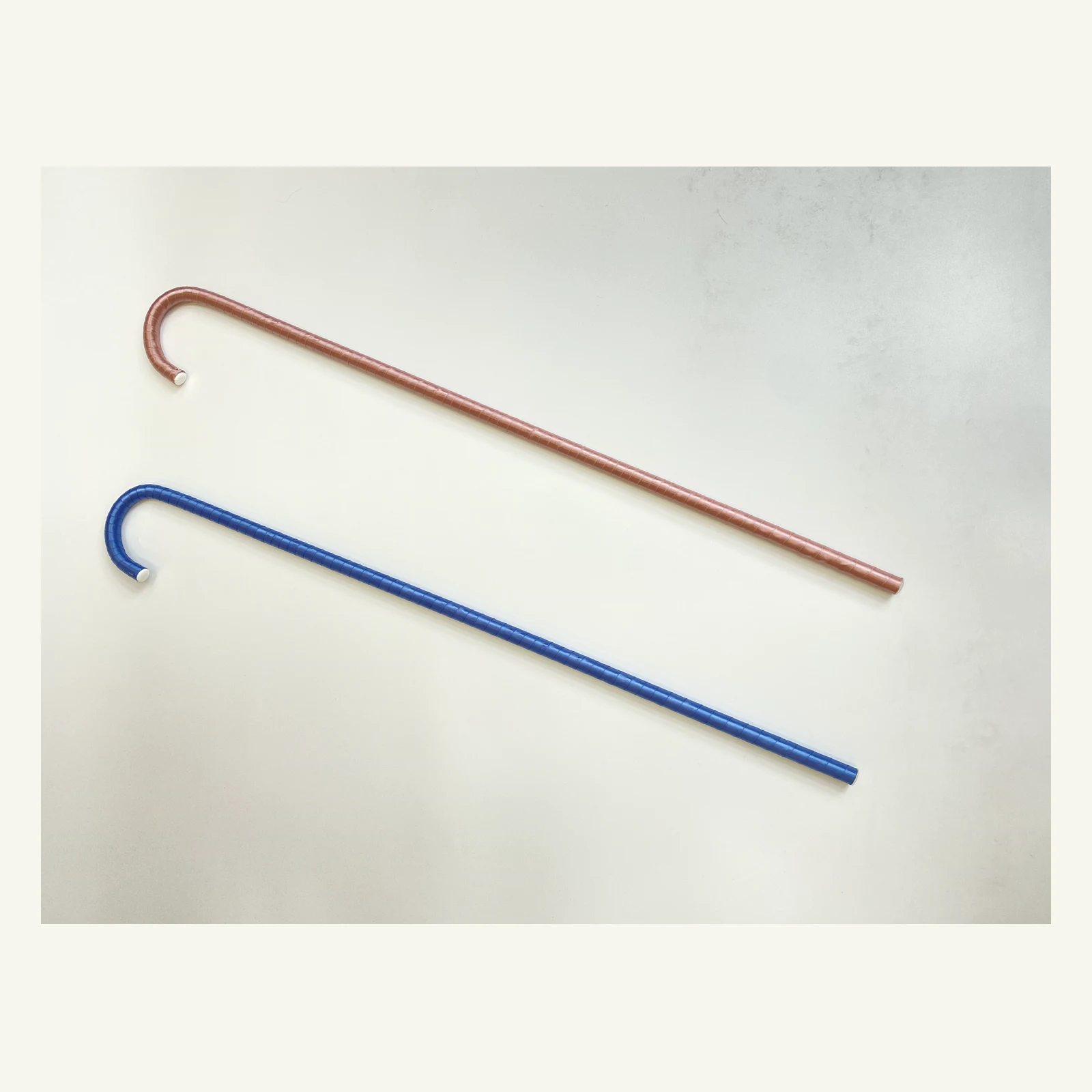 Blue and pink satin-wrapped ballet canes laid side by side