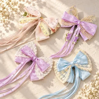 Four ballet hair bows with long ribbons in blush rose, lavender, lilac and powder blue on a cream background