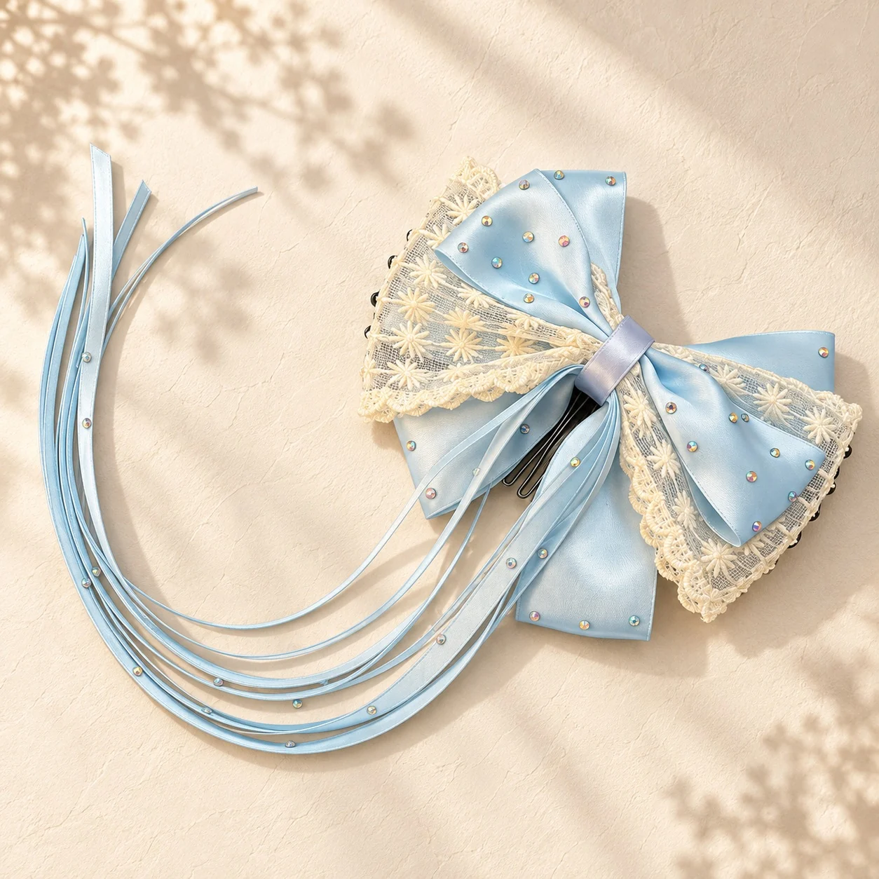 Powder blue satin hair bow with cream lace and long pearl-studded ribbons