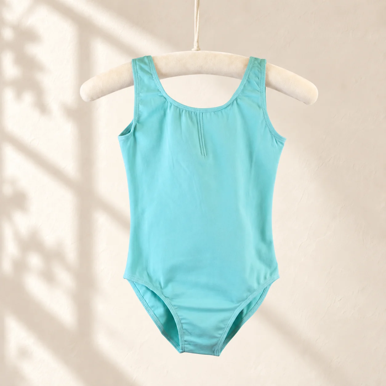 Aqua sleeveless cotton ballet leotard on a hanger