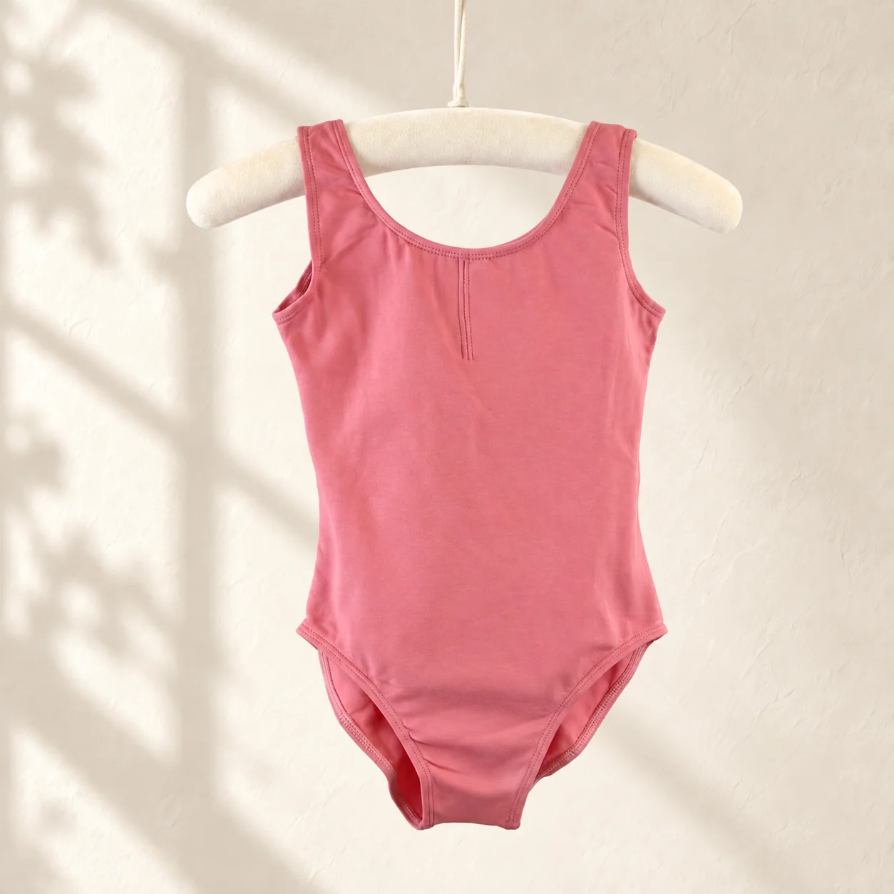 Dusty rose sleeveless cotton ballet leotard on a hanger