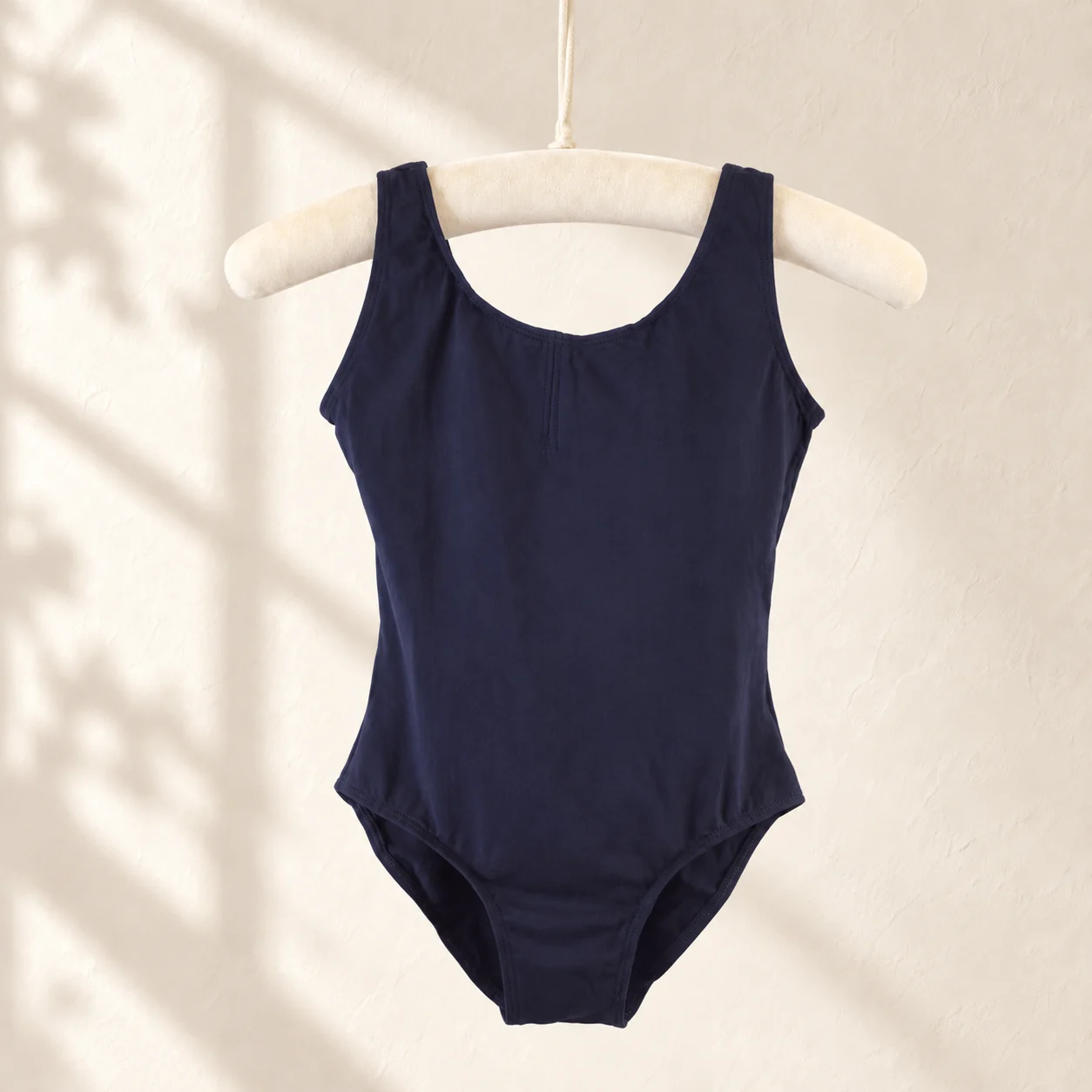 Navy sleeveless cotton ballet leotard on a hanger