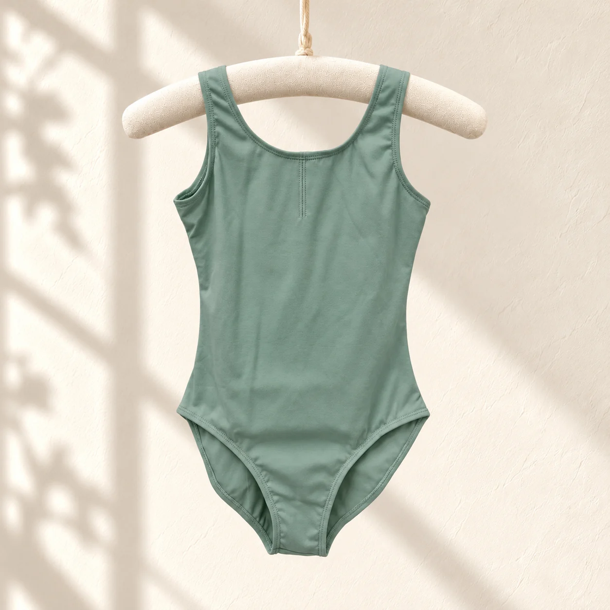 Sage green sleeveless nylon ballet leotard on a hanger