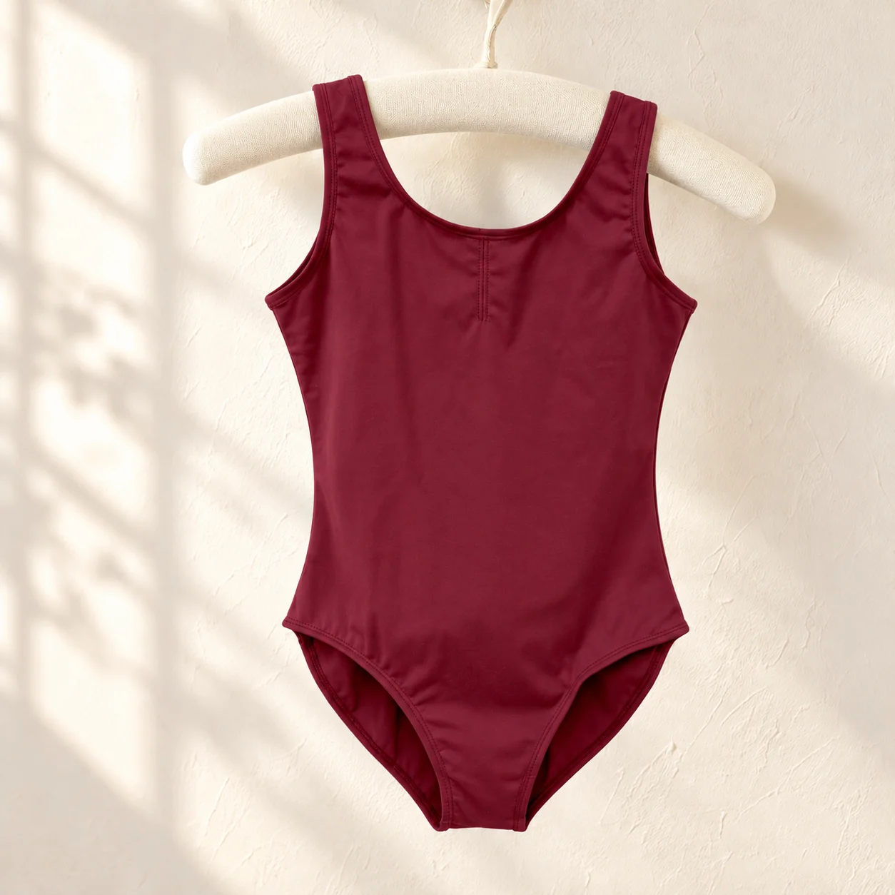 Wine red sleeveless nylon ballet leotard on a hanger