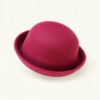 Pink felt bowler hat with a rolled brim on a white background