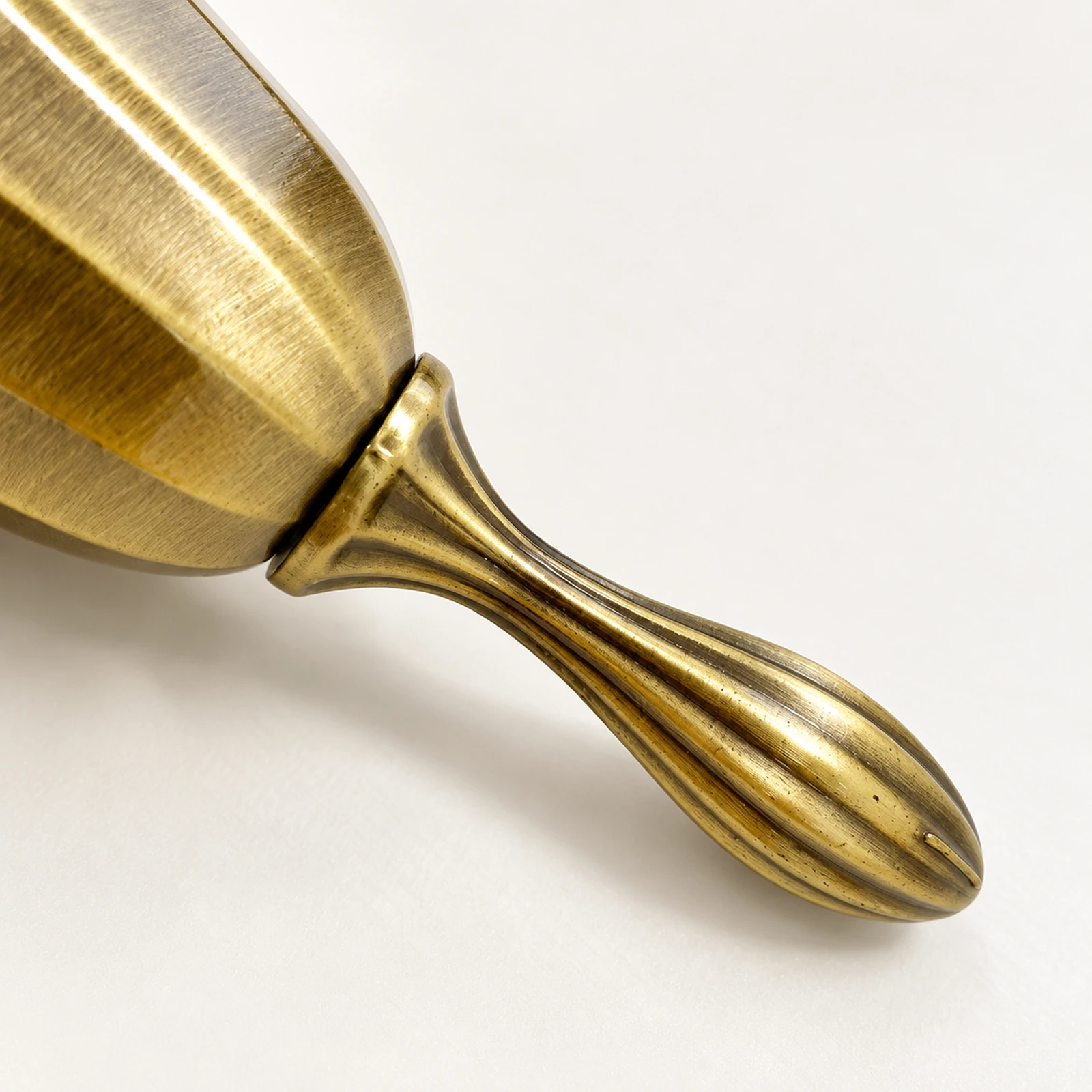 Close-up of the grooved handle of the brass hand bell
