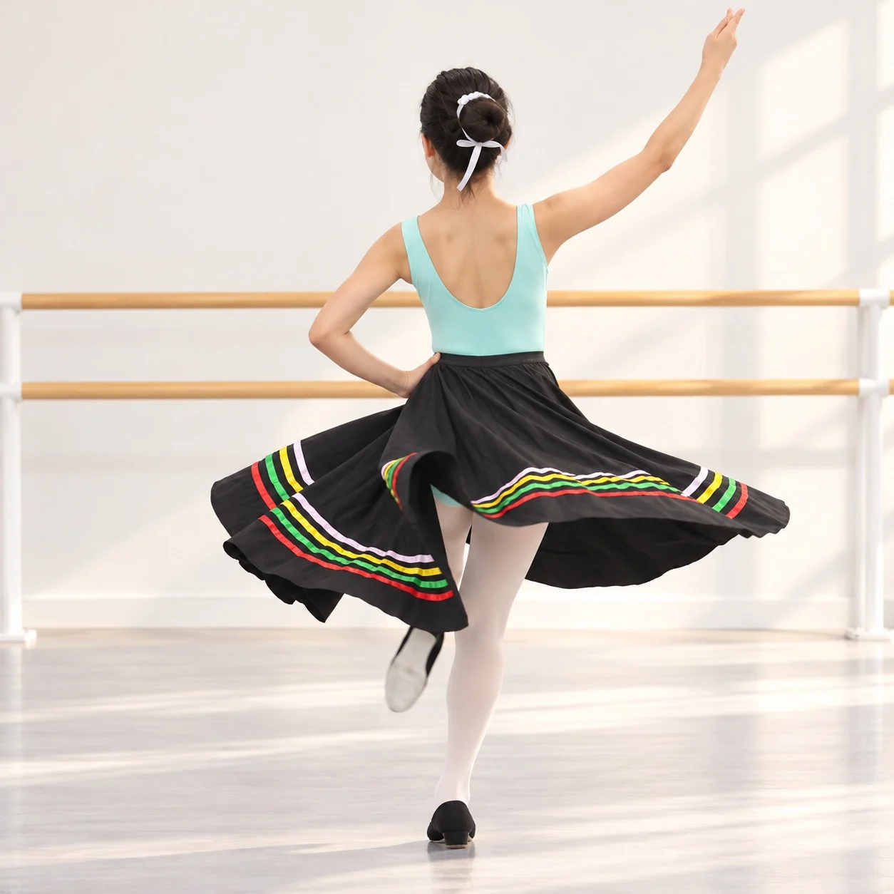 Dancer in a turquoise leotard and black character skirt turning on one leg in a ballet studio