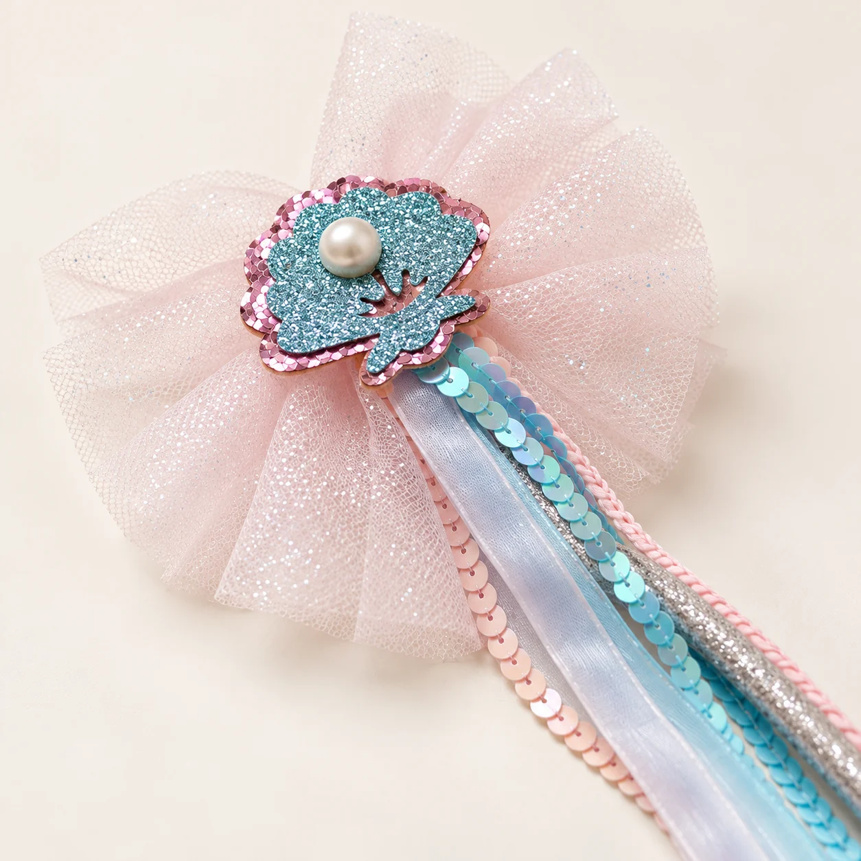 Close-up of the glittery shell ornament with a pearl and pink tulle at the top of the wand