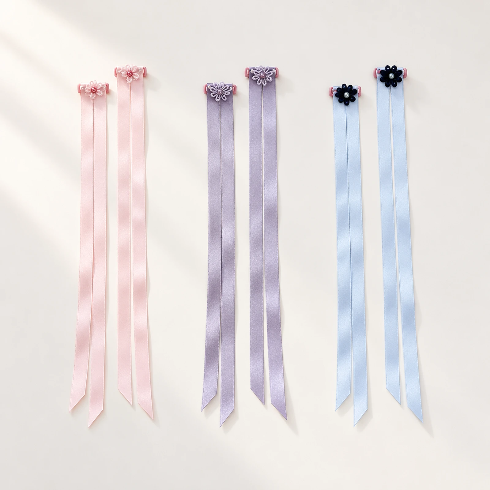 Three pairs of satin finger ribbons in blush pink, mist lavender and pale blue