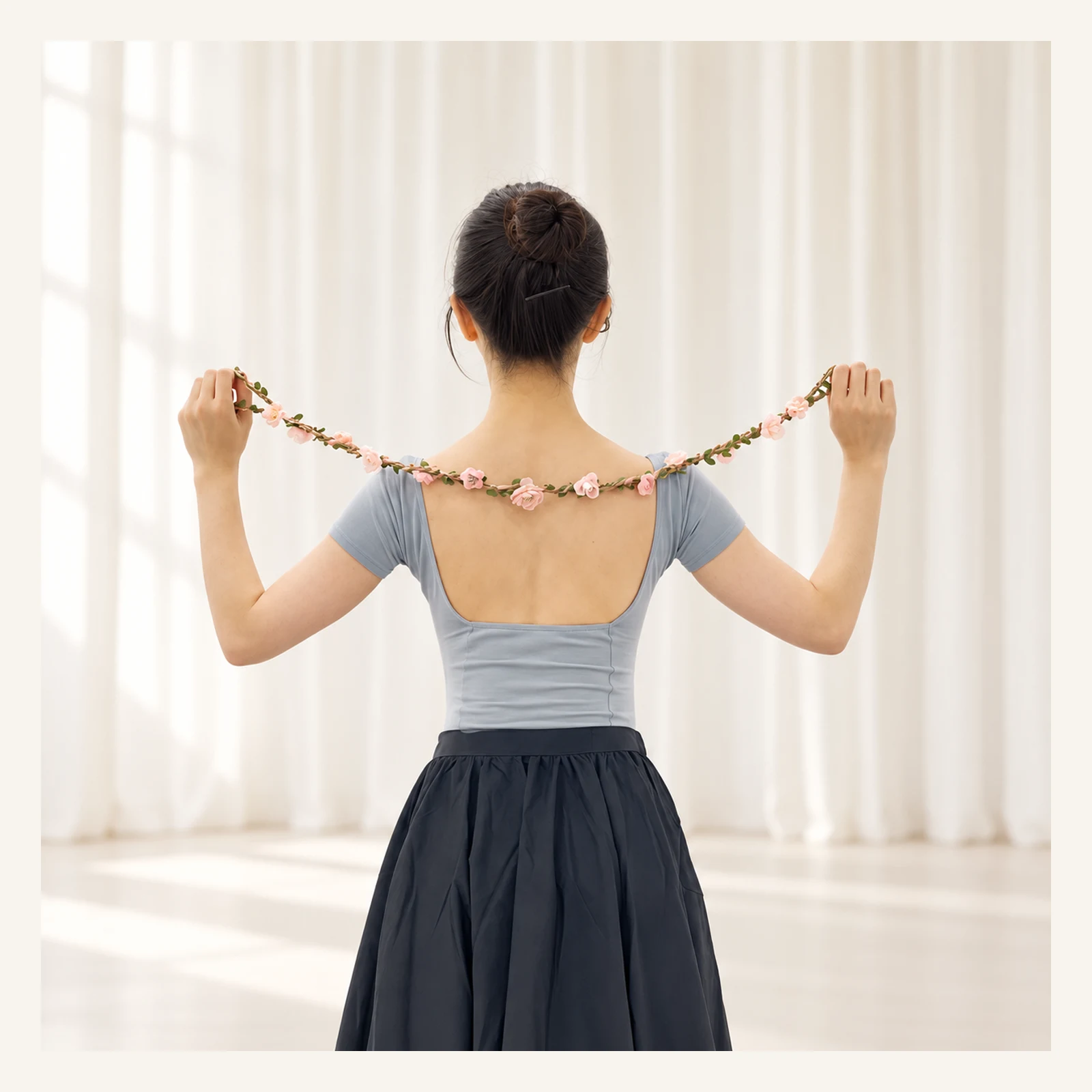 Dancer seen from behind holding the flower wreath behind her shoulders