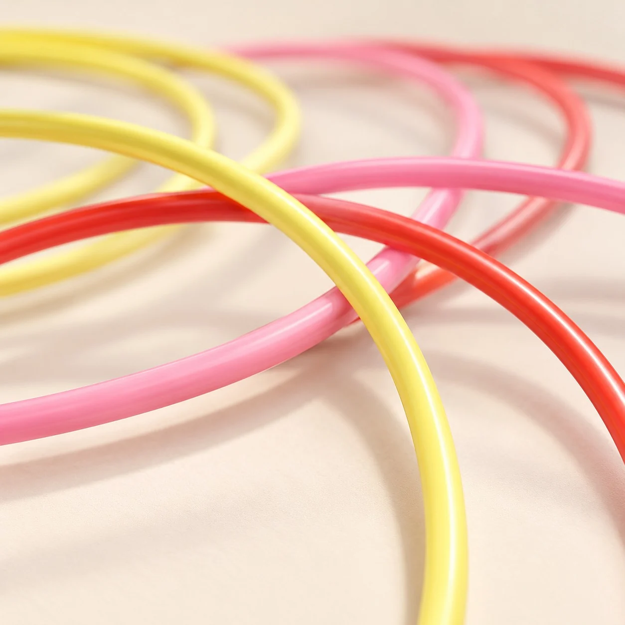Close-up of the smooth round tubing of yellow, pink and red hoops