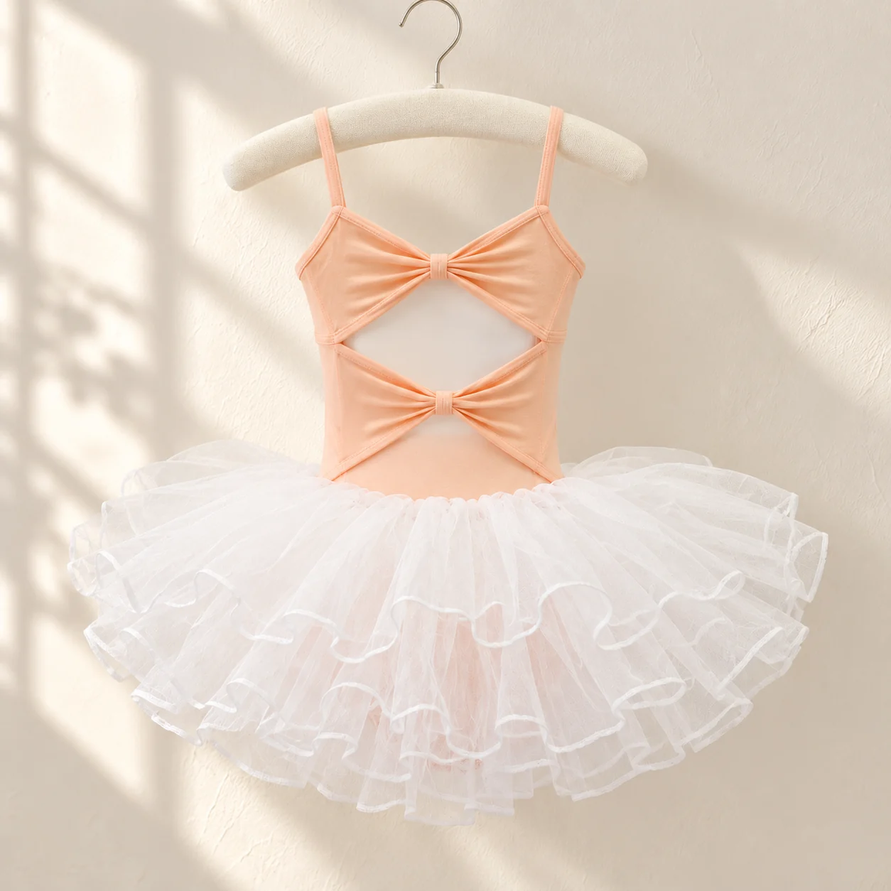 Back of the orange camisole leotard with a cross-over bow and open back, with a white tutu skirt