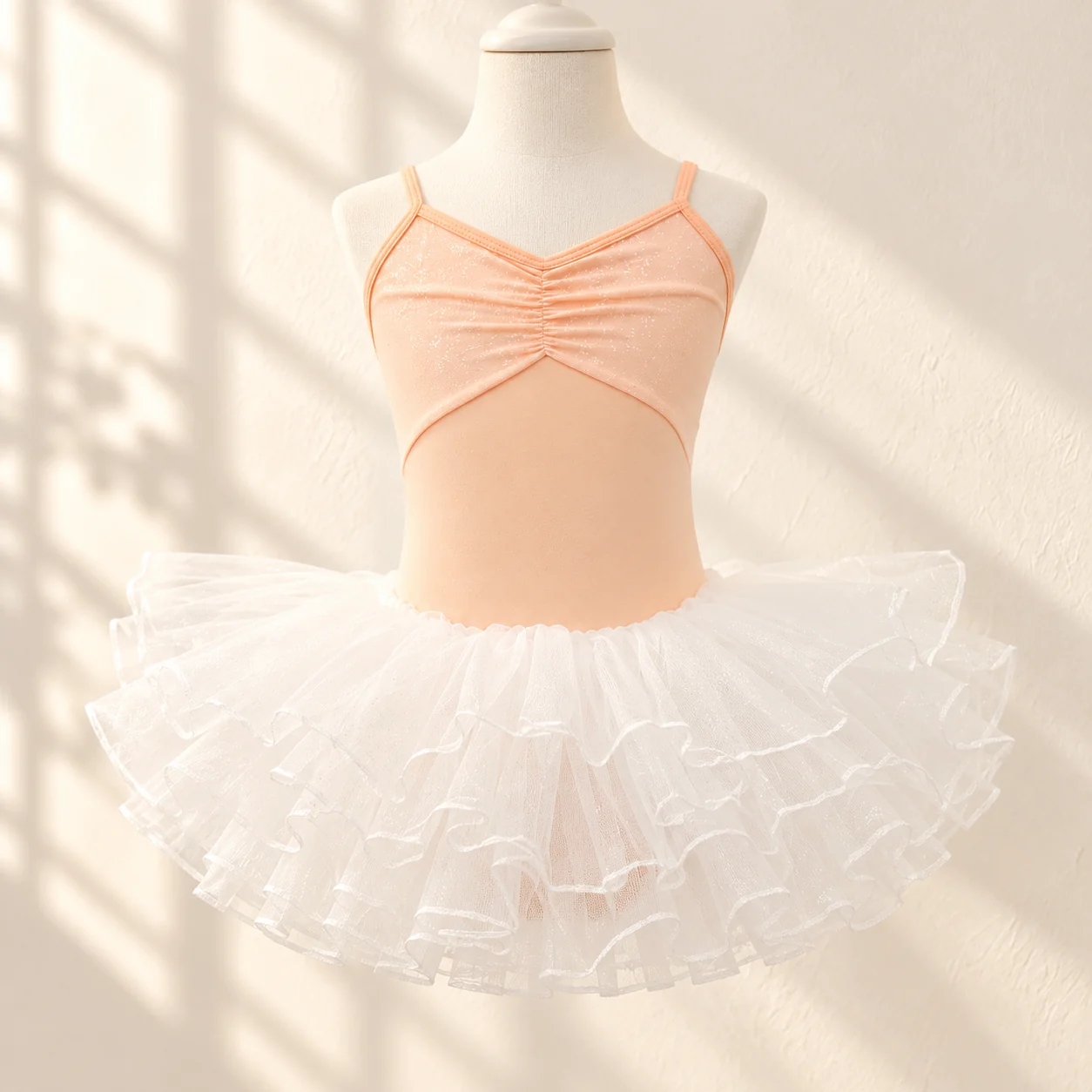 Orange camisole leotard and white tulle tutu skirt shown at an angle on a mannequin