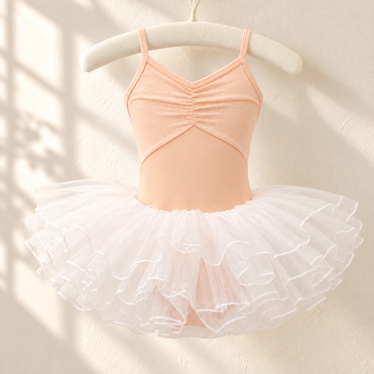 Front of the orange camisole leotard with gathered bodice and white tutu skirt on a hanger